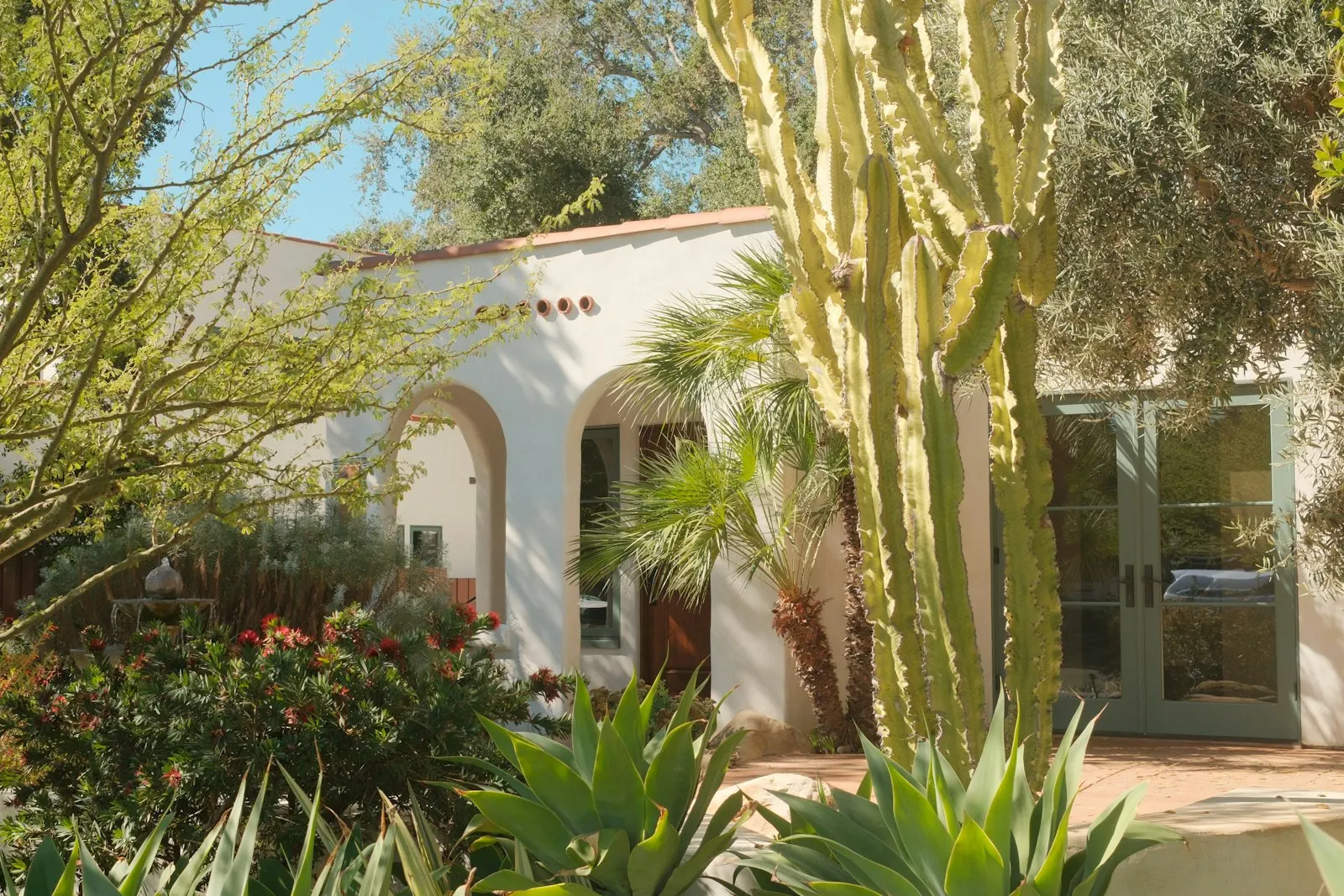 Spanish-style Tucson home with desert landscaping out front, mesquite shade